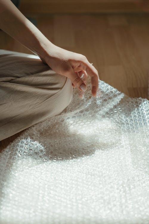 A hand sorting clean reusable bubble wrap